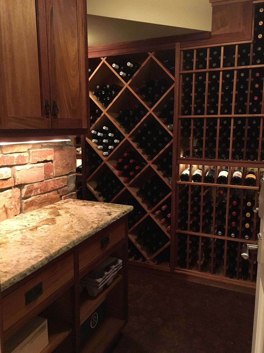 Traditional wine storage room with brick accents and wood cabinetry, designed by MA Peterson in Twin Cities