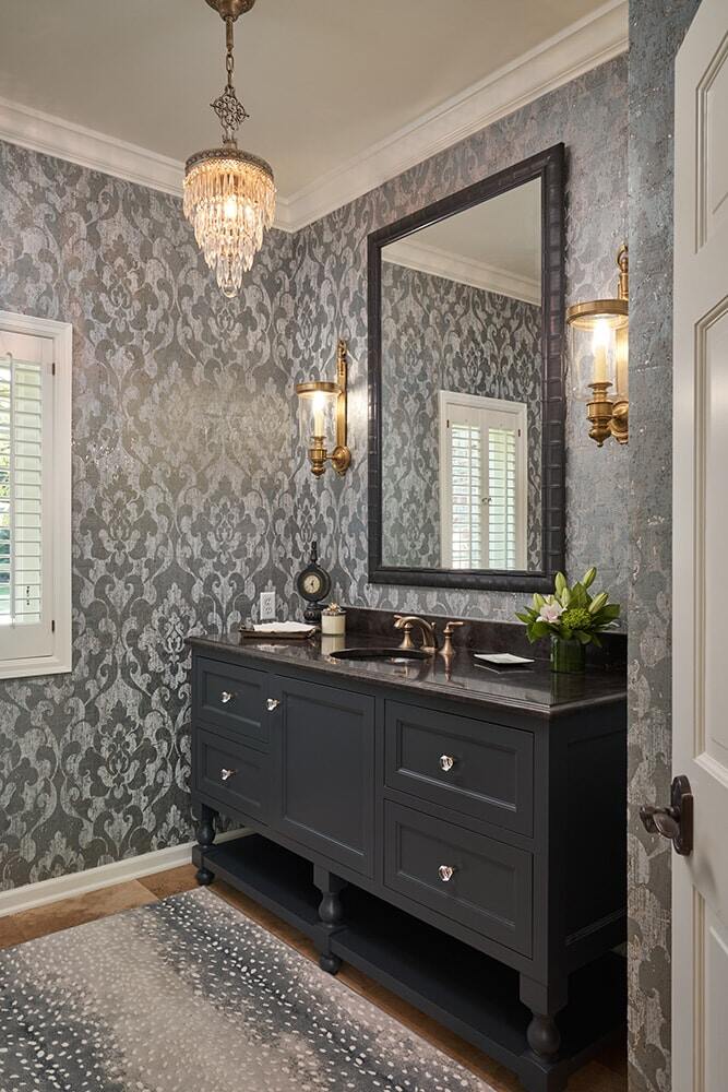 Elegant bathroom remodel with dark vanity and chandelier by MA Peterson in Twin Cities