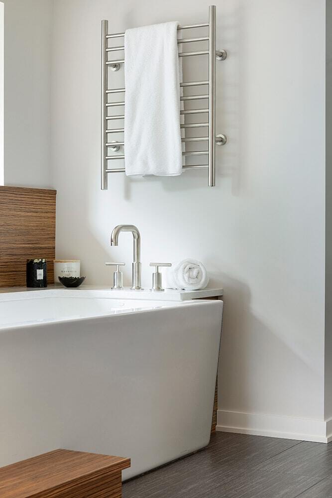 Minimalist bathroom with sleek tub and towel warmer by MA Peterson in the Twin Cities
