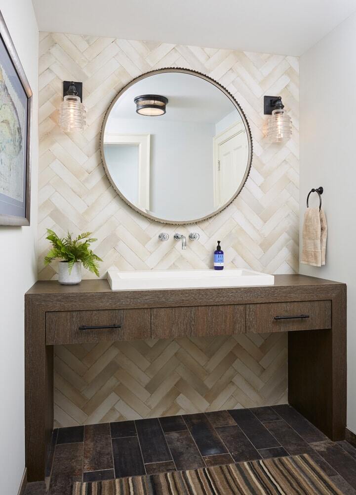 Rustic bathroom vanity with a herringbone tile wall, remodeled by MA Peterson in the Twin Cities