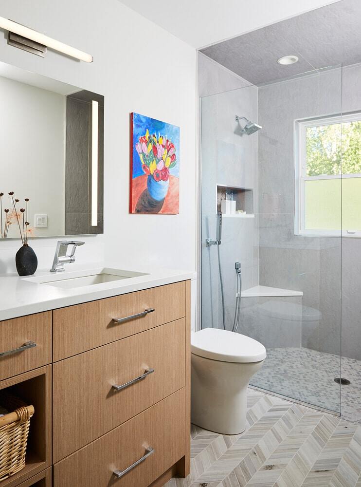 Sleek bathroom design with glass shower and wooden vanity by MA Peterson in Twin Cities