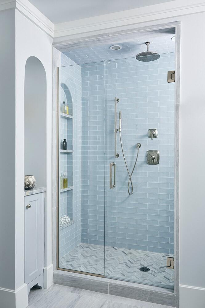 Sleek glass-enclosed shower with blue tiles, remodeled by MA Peterson in Twin Cities