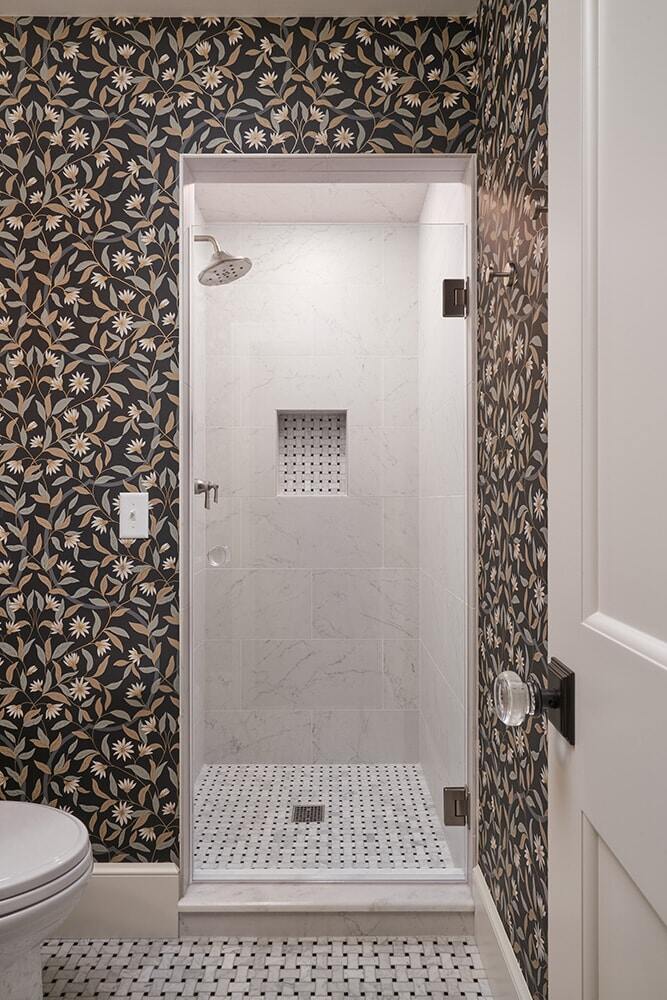 Stylish bathroom featuring a marble shower and floral patterned wallpaper, remodeled by MA Peterson in the Twin Cities