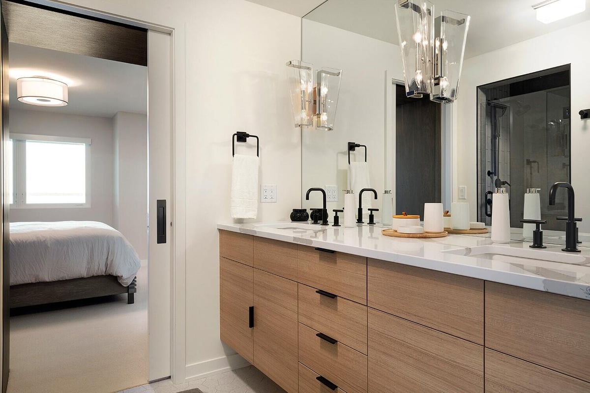 Stylish bathroom with black fixtures and wooden vanity by MA Peterson in the Twin Cities