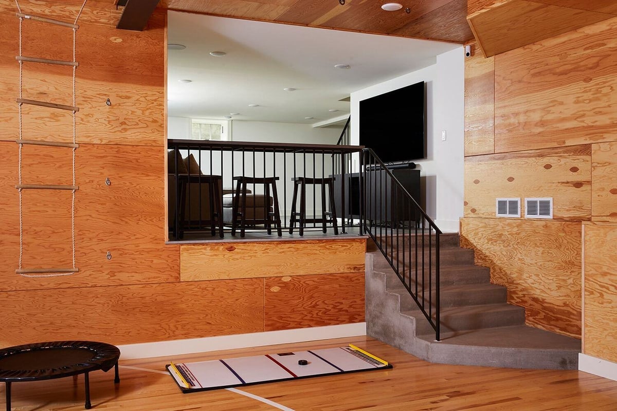 Indoor sports room with a view of a lounge area above, designed by MA Peterson in the Twin Cities