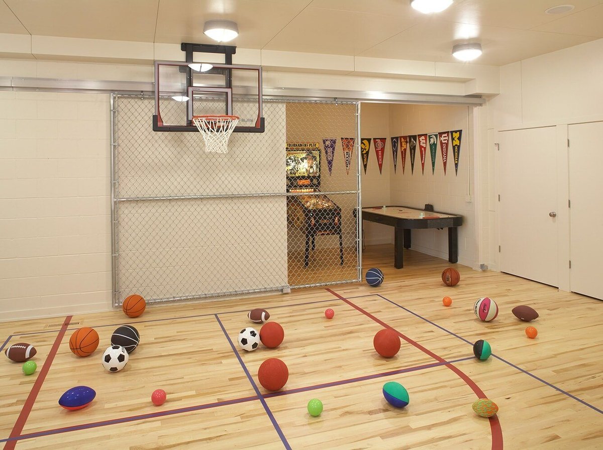 Multi-sport indoor gym with various balls on the floor, designed by MA Peterson in the Twin Cities