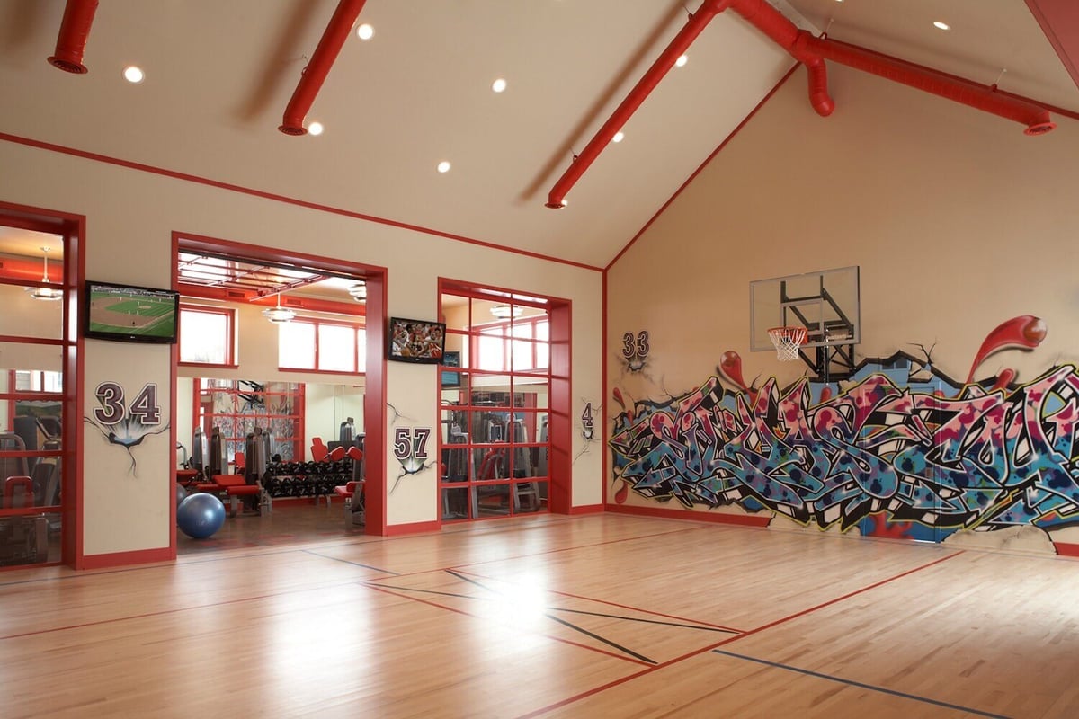 Spacious basketball court with graffiti wall art and viewing area, designed by MA Peterson in the Twin Cities