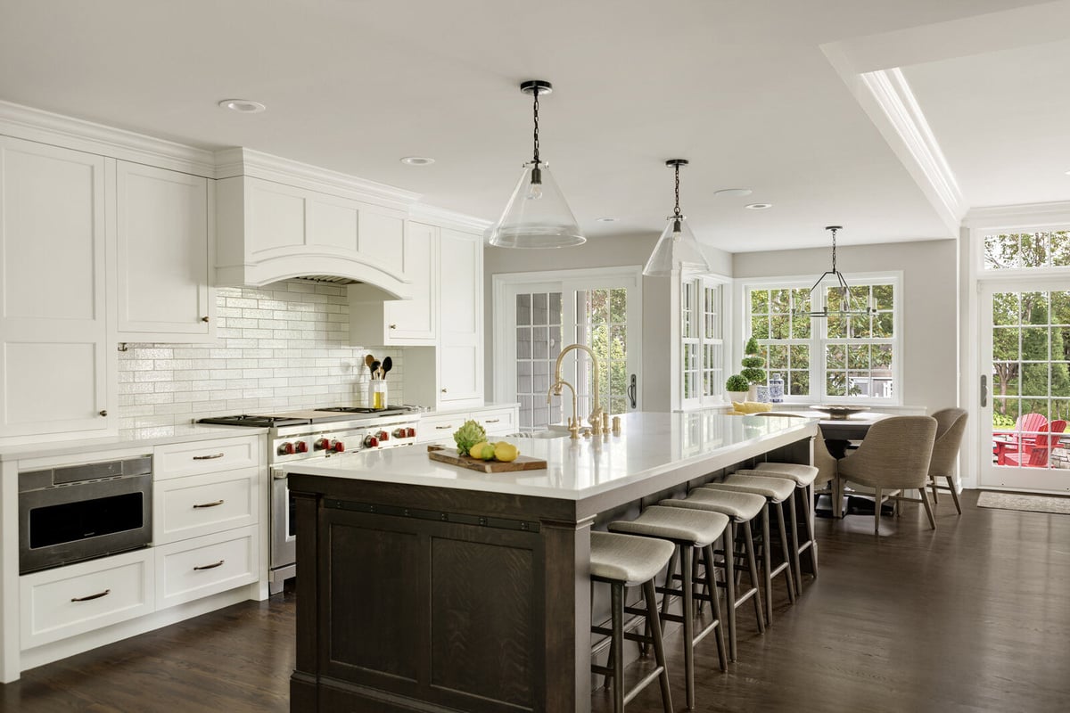 Classic white kitchen with a large island and pendant lighting in a Twin Cities home remodel by MA Peterson