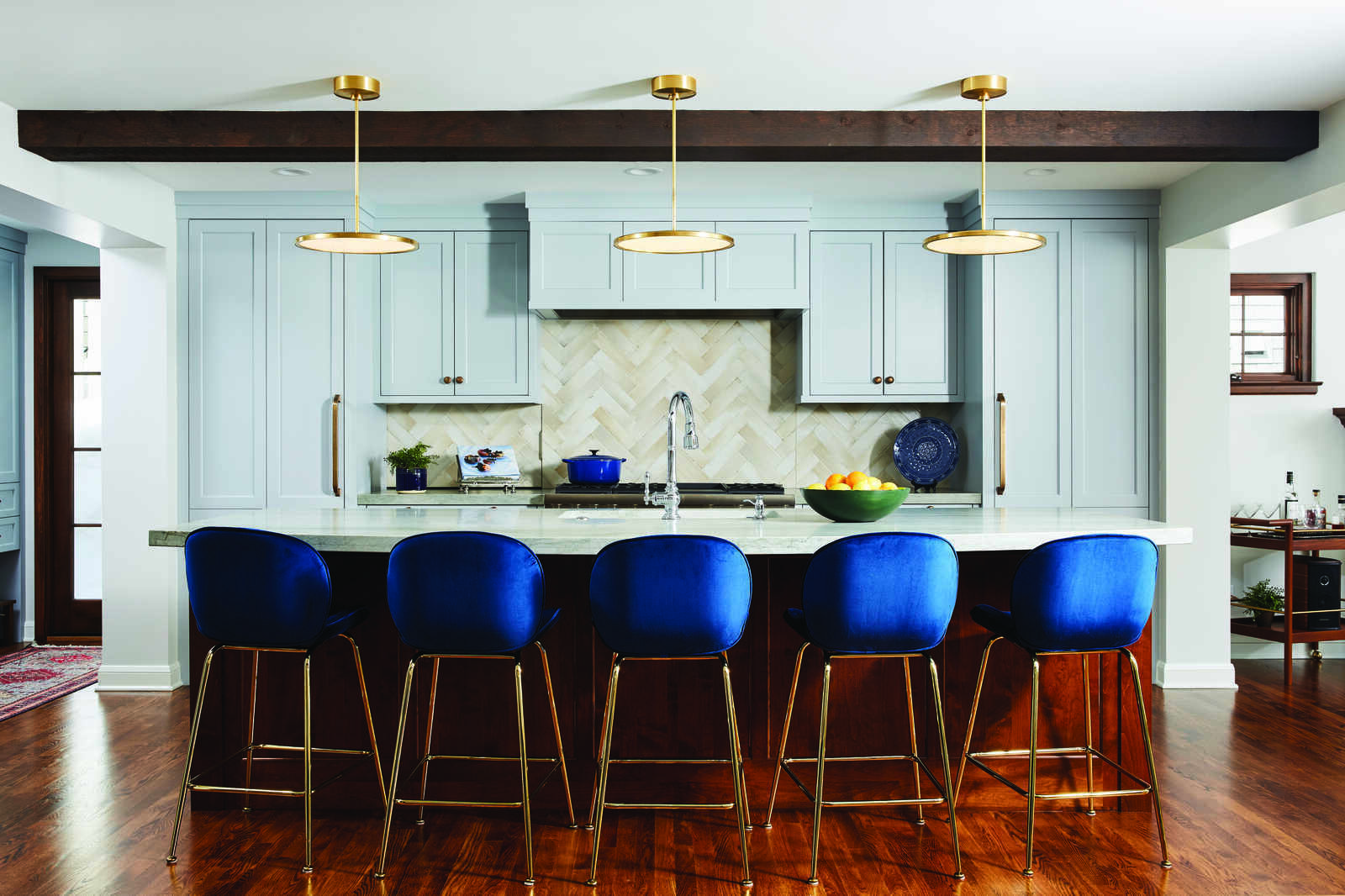Stylish kitchen with blue chairs and gold pendant lights by MA Peterson in the Twin Cities