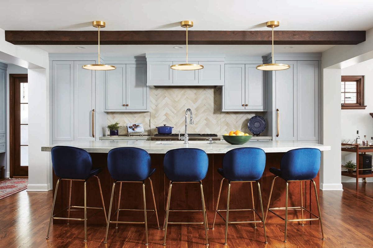 Stylish kitchen with blue chairs and gold pendant lights by MA Peterson in the Twin Cities