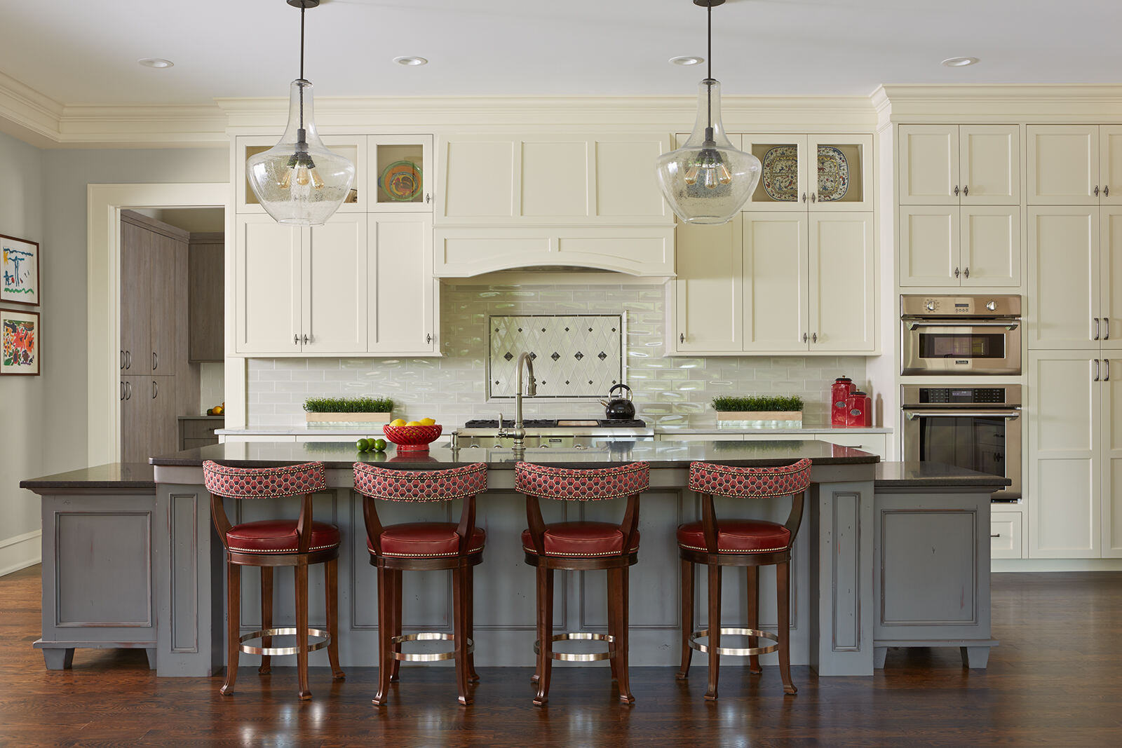 Traditional kitchen remodel with white cabinets and red bar stools by MA Peterson in the Twin Cities