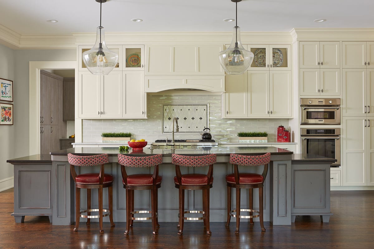 Traditional kitchen remodel with white cabinets and red bar stools by MA Peterson in the Twin Cities