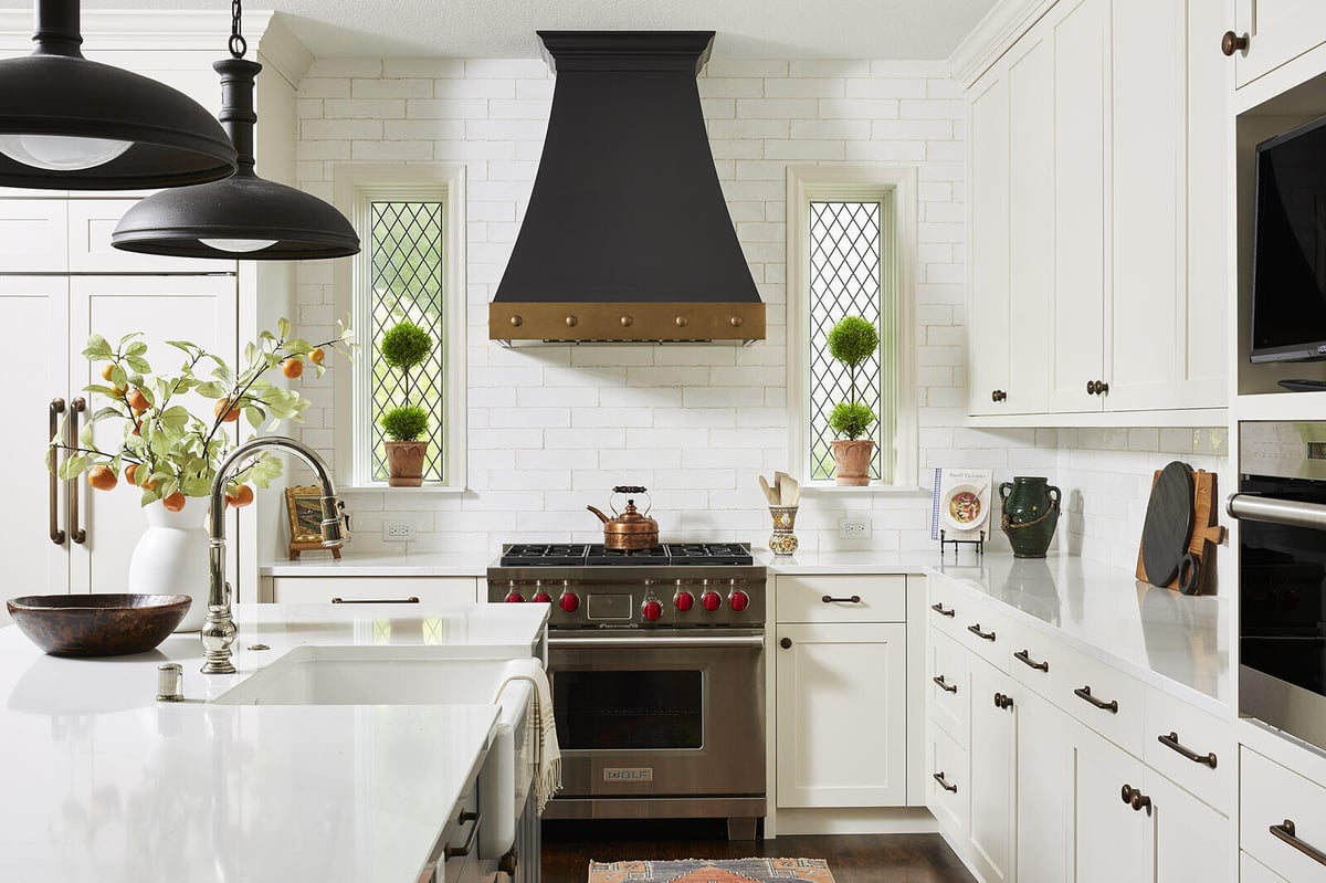 White kitchen with black range hood and pendant lighting in a Twin Cities home remodel by MA Peterson