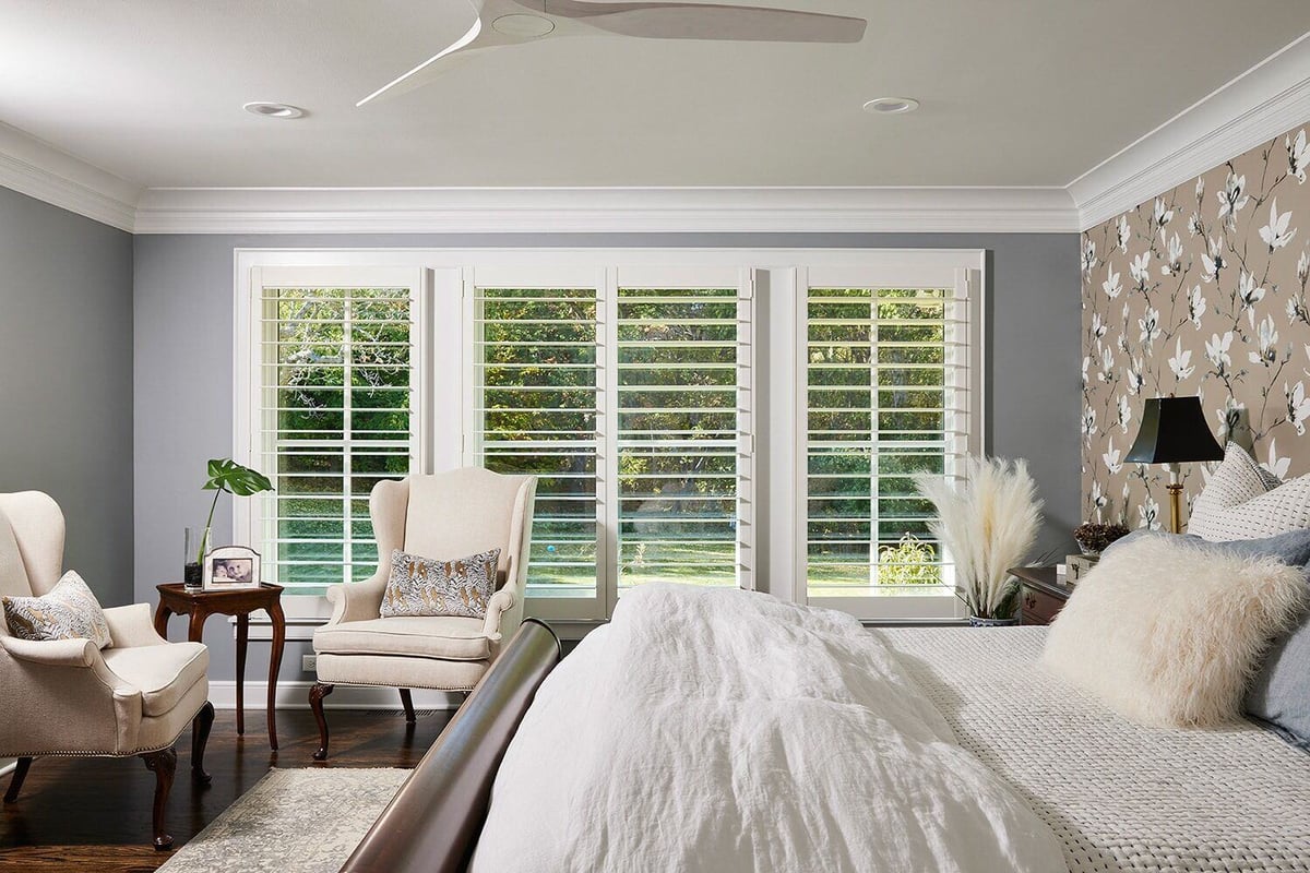 Bright bedroom with large windows and elegant decor, featuring a cozy seating area in a custom home by MA Peterson in the Twin Cities