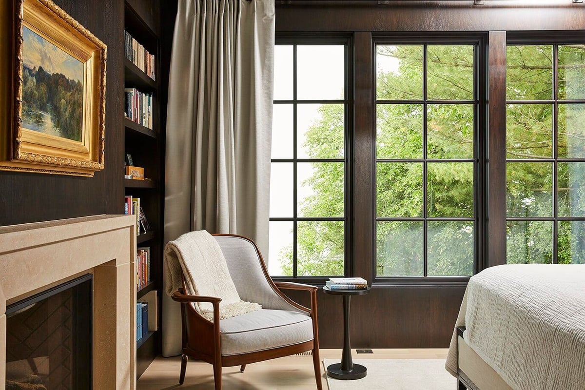 Charming bedroom with a reading area by the window and a fireplace, part of a remodel by MA Peterson, Twin Cities