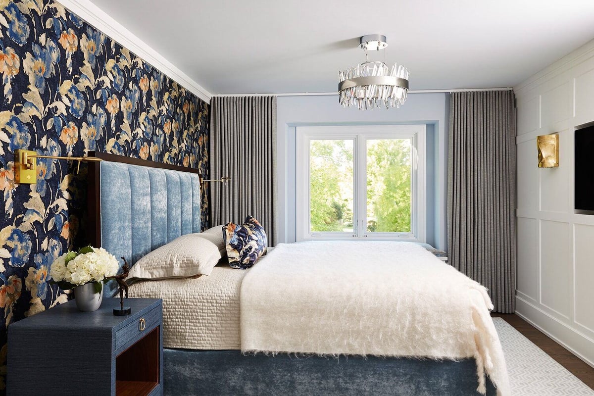 Luxurious bedroom with floral wallpaper and custom blue headboard by MA Peterson in the Twin Cities