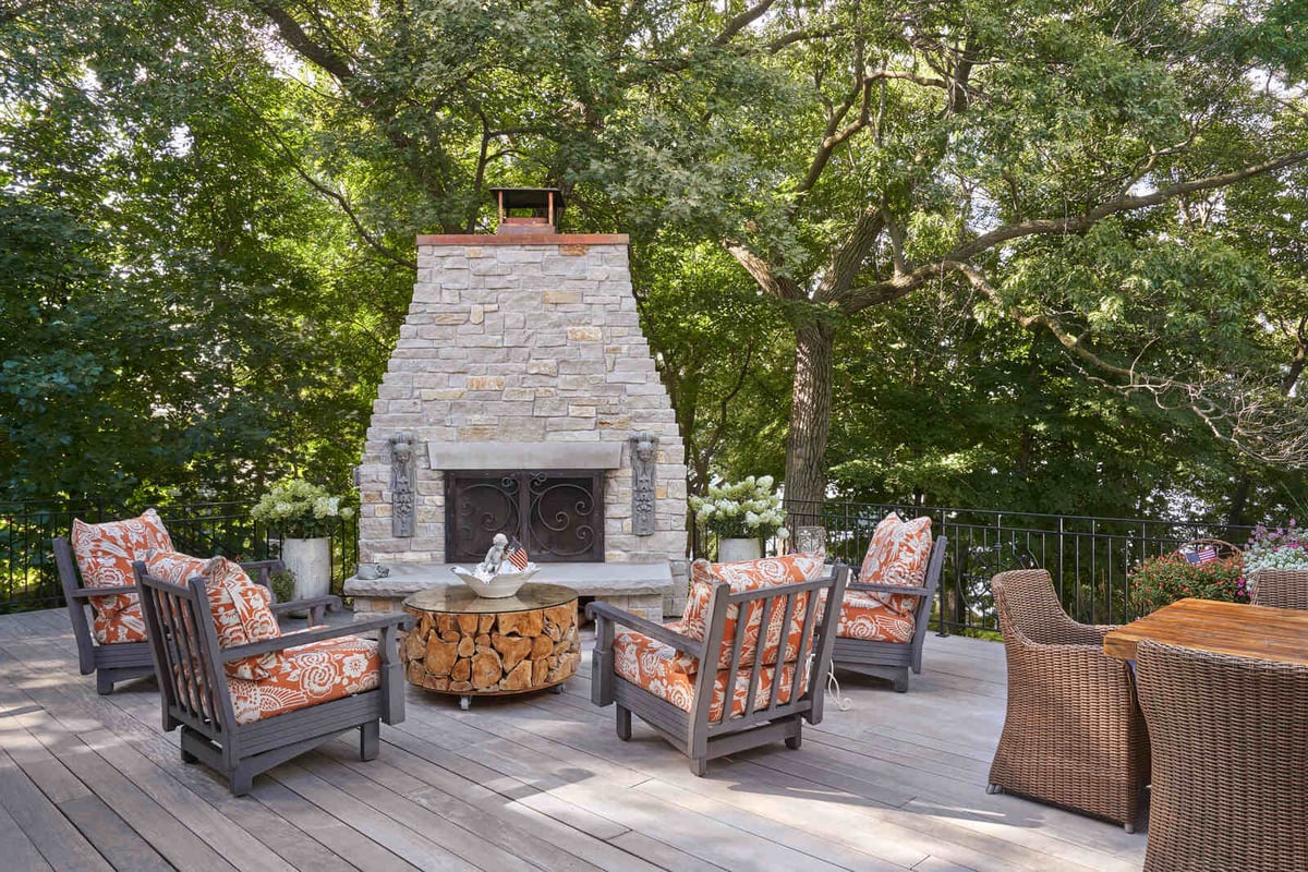 Outdoor patio with a large stone fireplace, designed by MA Peterson in the Twin Cities
