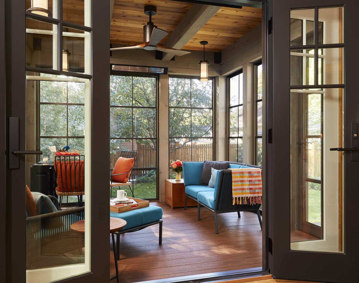 Stylish sunroom with teal seating, part of a custom home remodel by MA Peterson in the Twin Cities