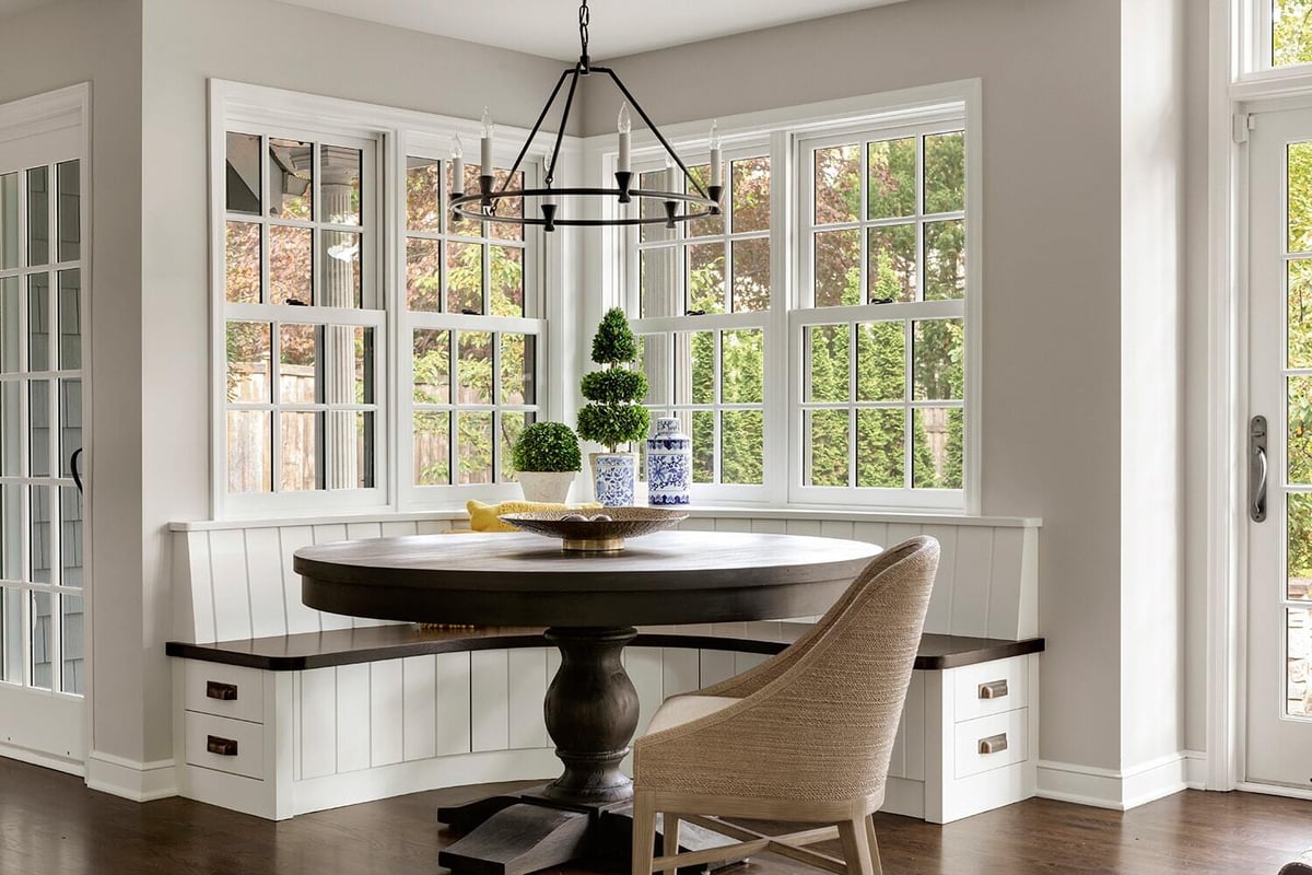 Bright breakfast nook with round table and built-in bench by MA Peterson in Twin Cities