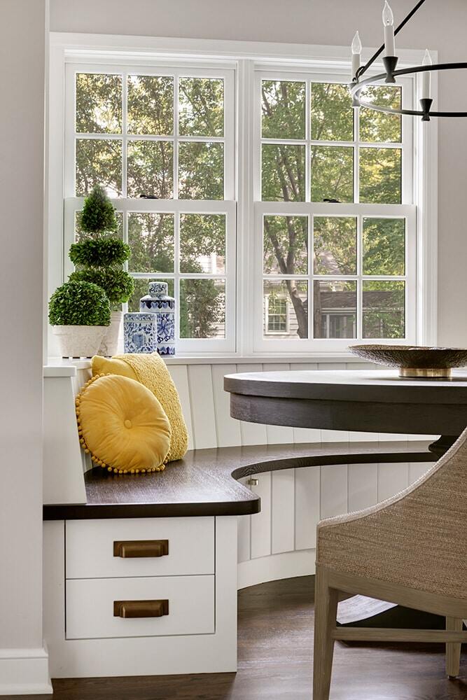 Detail view of breakfast nook seating area with yellow cushion and plants by MA Peterson, Twin Cities