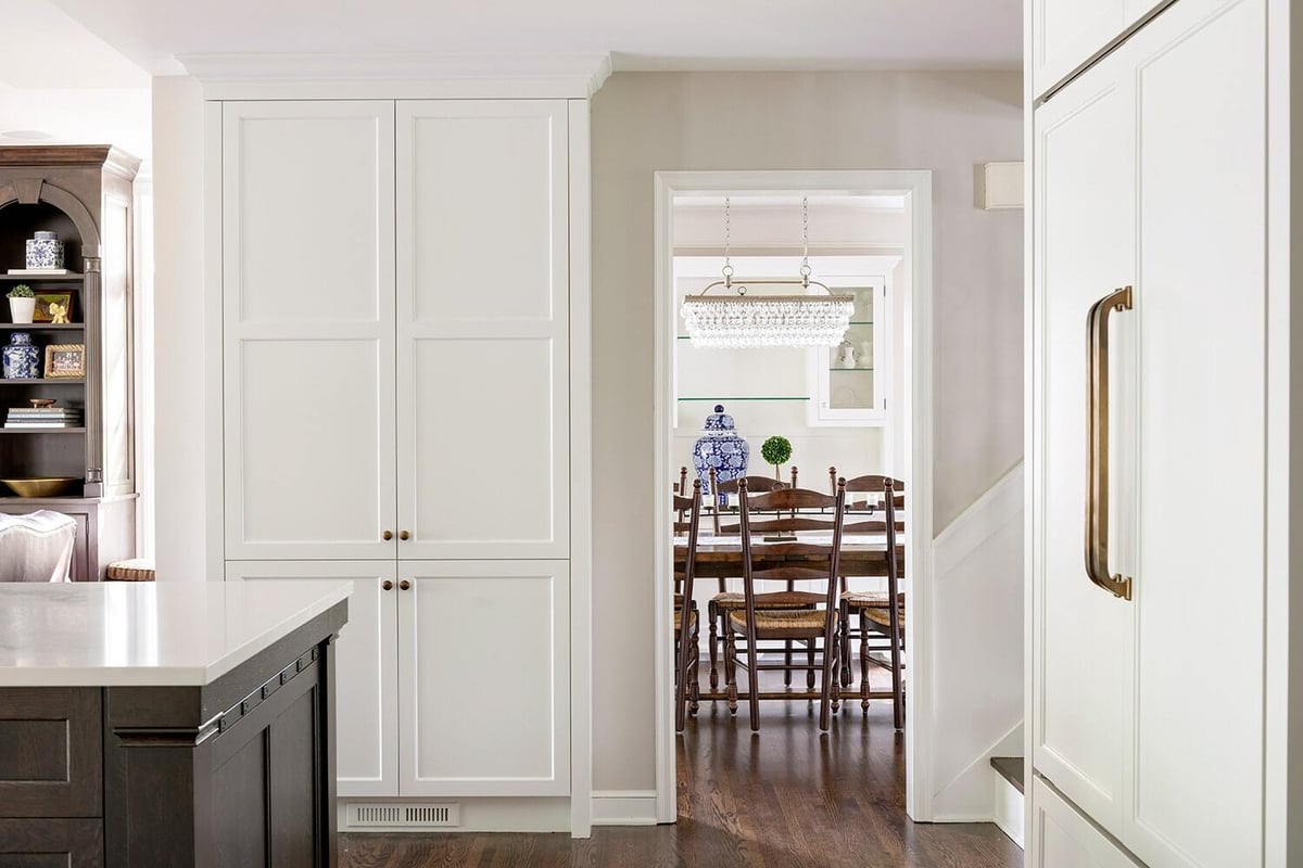 Modern kitchen design leading to dining area with white cabinetry, remodeled by MA Peterson in Twin Cities