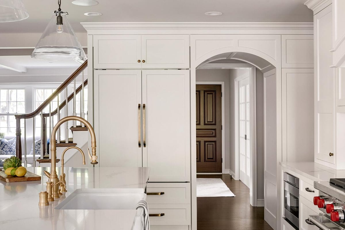 Sophisticated kitchen design with arched entryway and gold accents by MA Peterson, Twin Cities