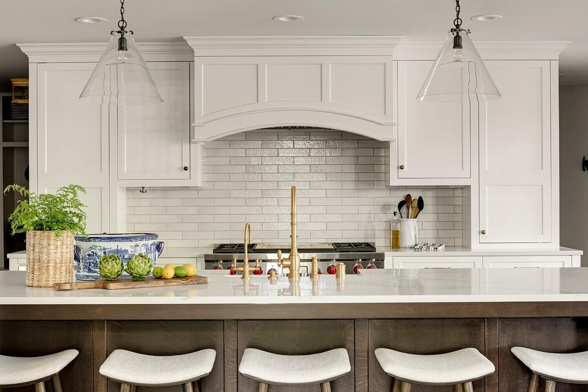 White kitchen with arched doorway and gold fixtures, remodeled by MA Peterson in Twin Cities