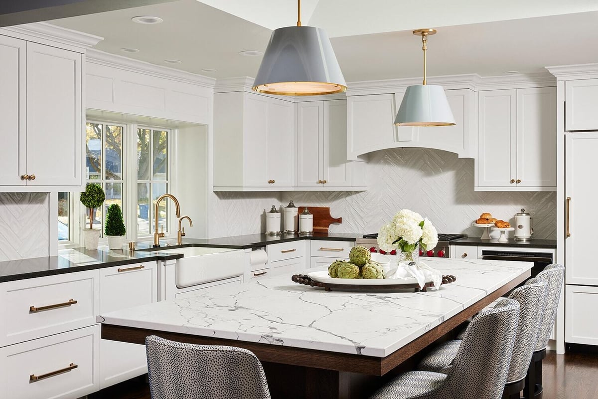 Sleek kitchen featuring marble countertops and pendant lights, part of a main level remodel by MA Peterson in Twi