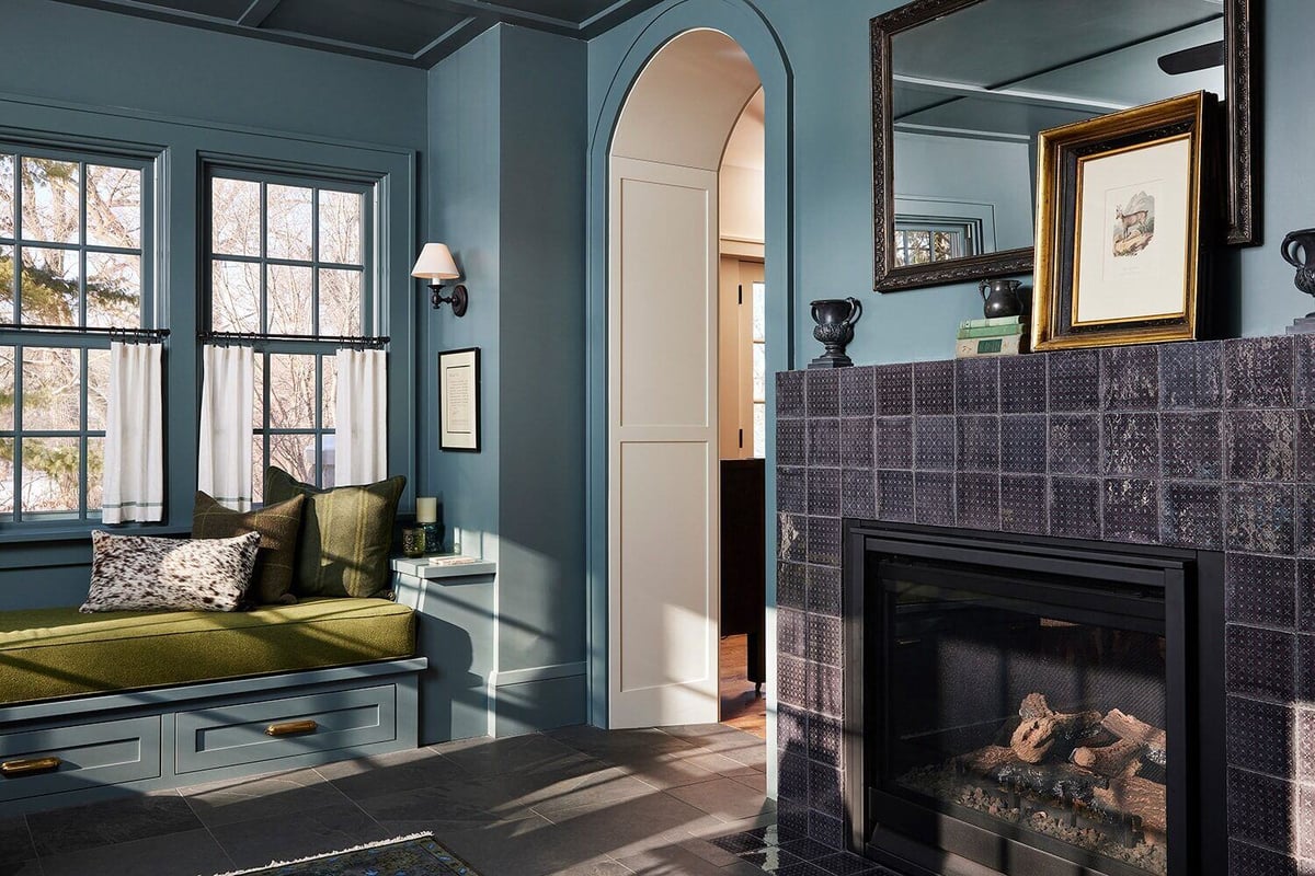 Cozy blue-themed room with a fireplace and built-in seating, part of MA Petersons vintage project in Twin Cities