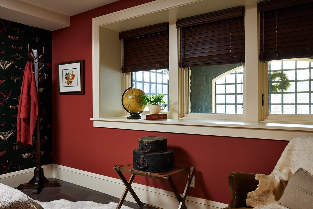 Cozy red-themed room with a window nook and vintage decor, designed by MA Peterson in Twin Cities