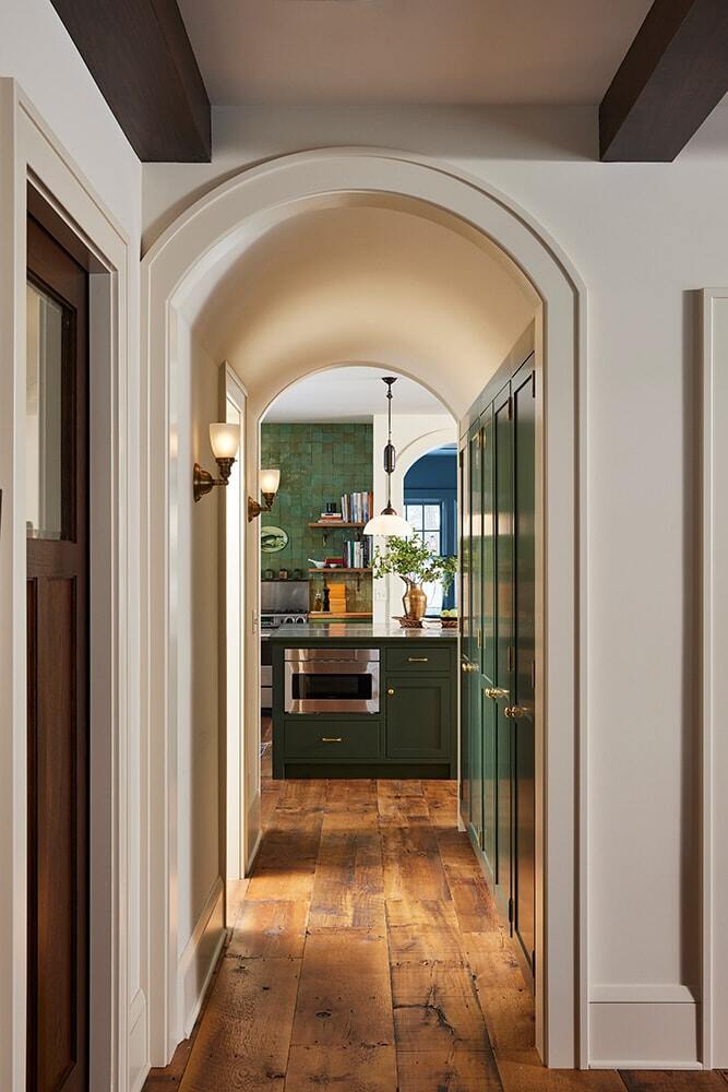 Hallway view leading to a green-themed kitchen, remodeled by MA Peterson in the Twin Cities