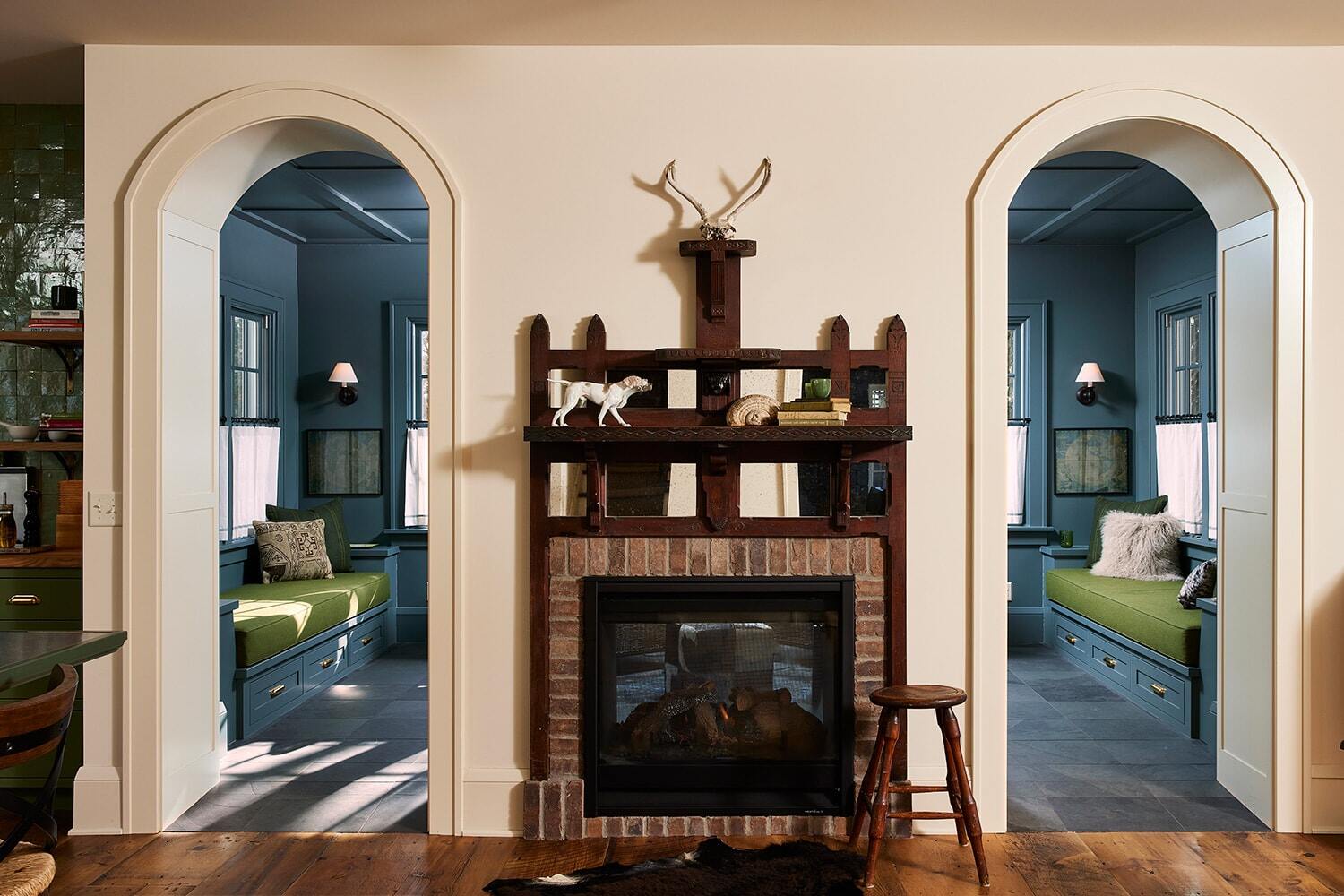 Rustic living room with dual archways and a central fireplace, part of MA Petersons Twin Cities project