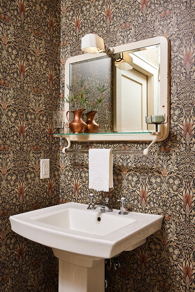 Vintage bathroom with intricate wallpaper and pedestal sink, part of MA Petersons Twin Cities project