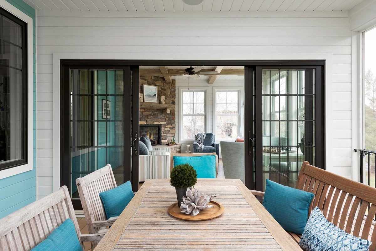 Outdoor dining space with a ceiling fan and blue accents in a Twin Cities custom home remodel by MA Peterson