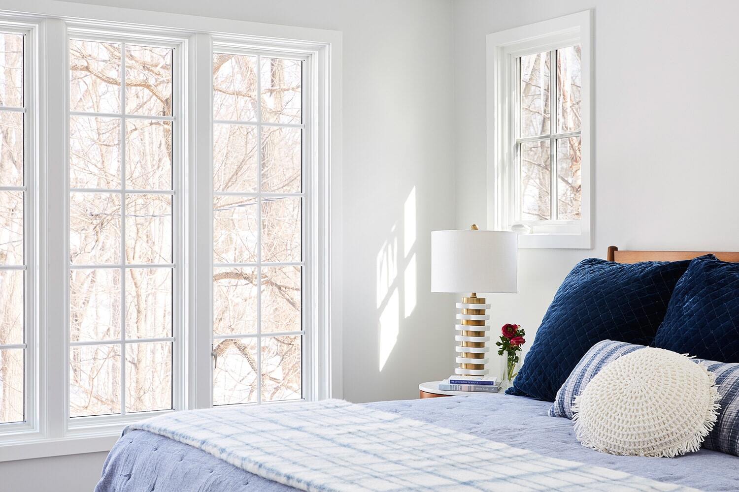 Bright bedroom with large windows and blue pillows in a home remodeled by MA Peterson in the Twin Cities