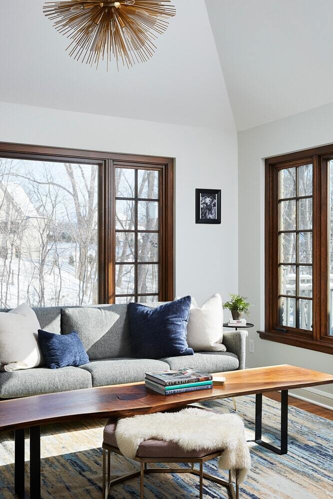 Sunlit living room with grey couch and modern decor in a home remodeled by MA Peterson in the Twin Cities