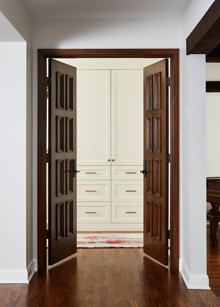 Wooden double doors leading to a built-in cabinet in a remodeled home by MA Peterson in the Twin Cities