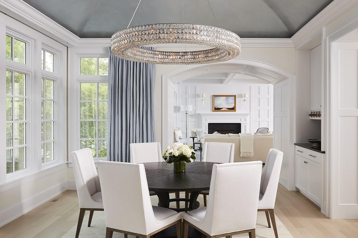 Dining area with a crystal chandelier in Coastal Chic home, remodeled by MA Peterson in Twin Cities