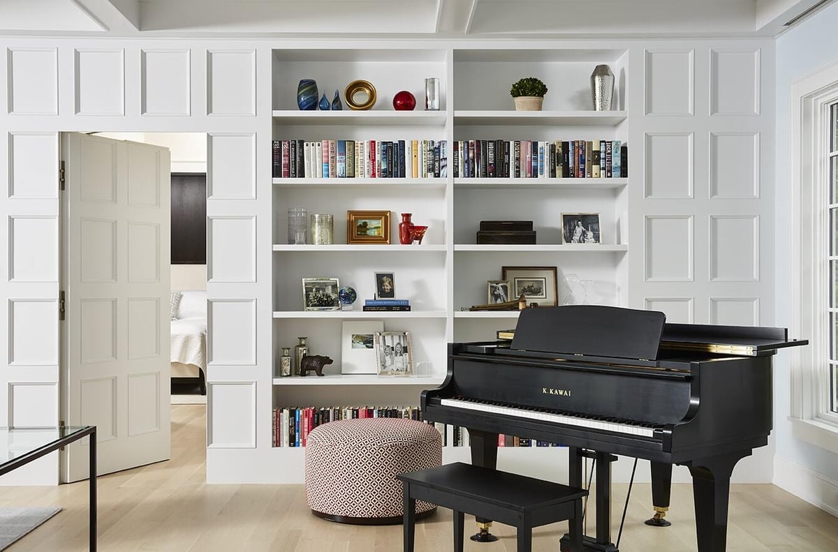 Elegant living room with piano and built-in shelving in Coastal Chic home, remodeled by MA Peterson in Twin Cities