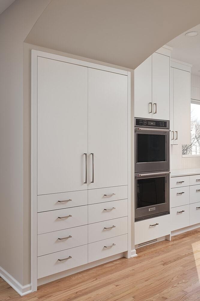 Modern kitchen cabinetry and double ovens in Crafting Warmth in Modern home by MA Peterson, Twin Cities