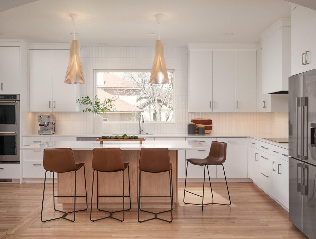 Modern kitchen with island and bar seating in Crafting Warmth in Modern home by MA Peterson, Twin Cities