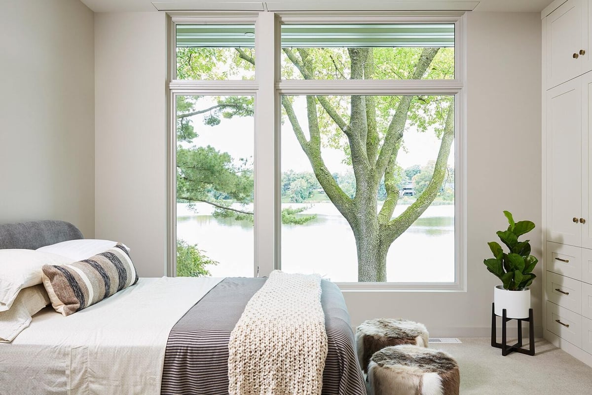 Bedroom with large window overlooking Lake Cornelia, remodeled by MA Peterson in Twin Cities