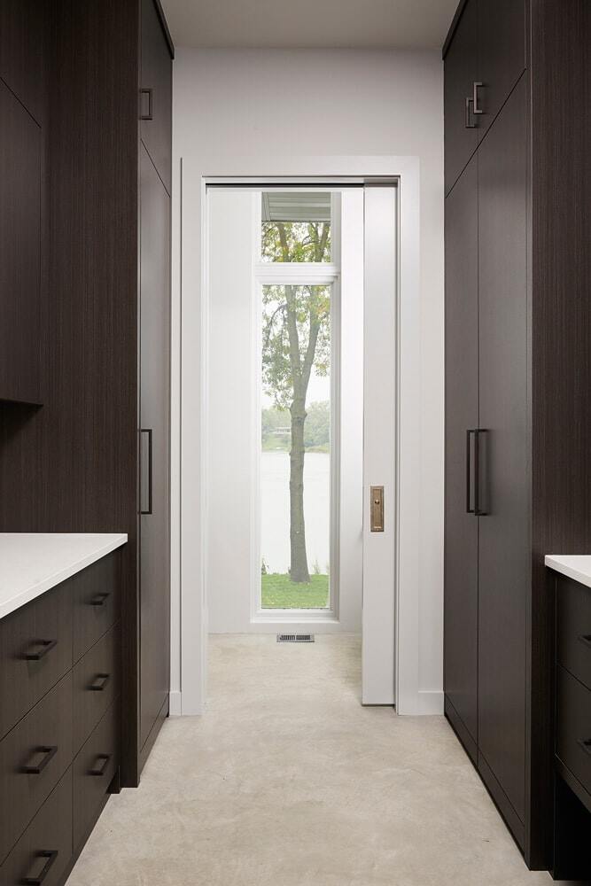 Hallway with dark cabinetry and lake view window in Lake Cornelia remodel by MA Peterson, Twin Cities