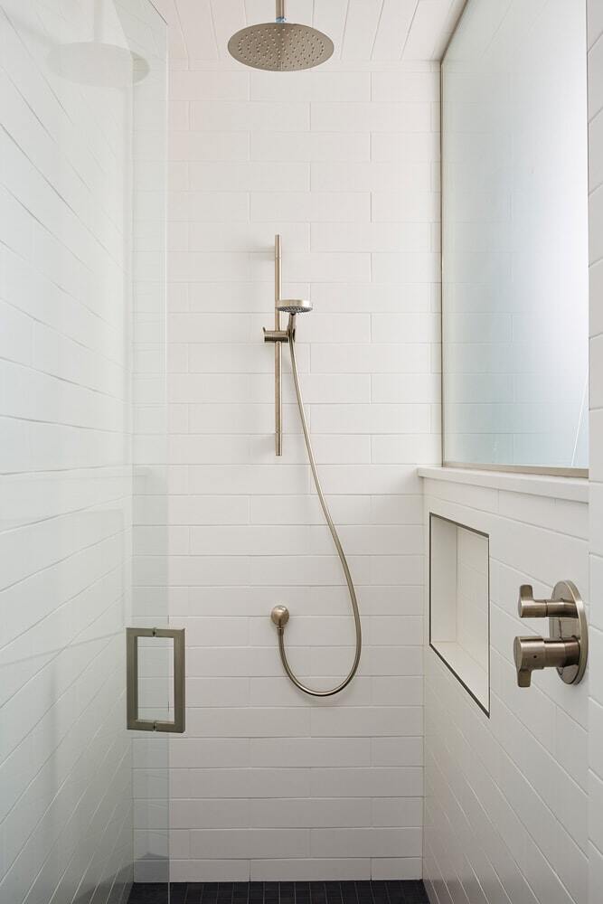 Modern bathroom with brass details and a view of Lake Cornelia, remodeled by MA Peterson in Twin Cities