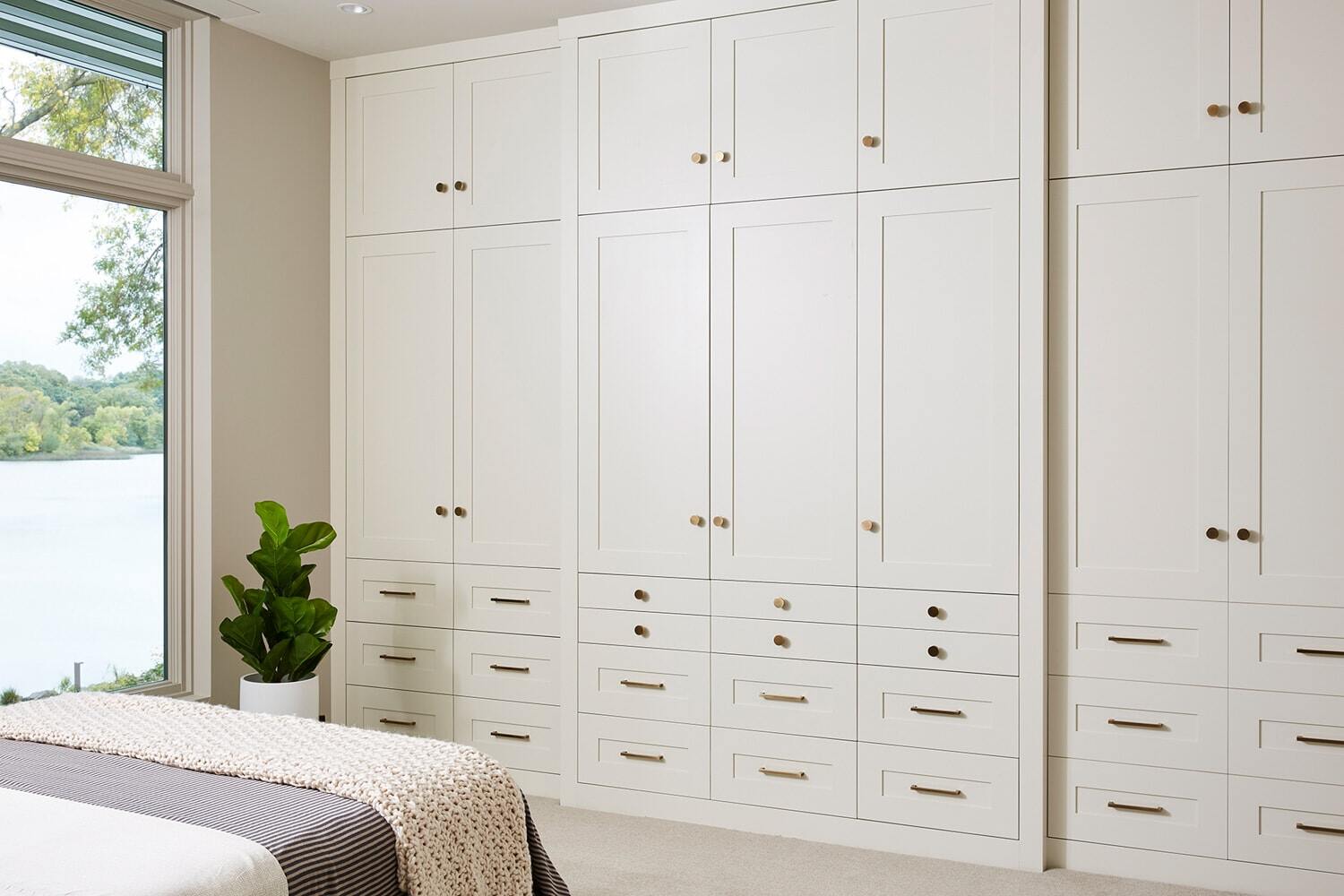 Modern bedroom with extensive cabinetry and lake view, remodeled by MA Peterson in Twin Cities