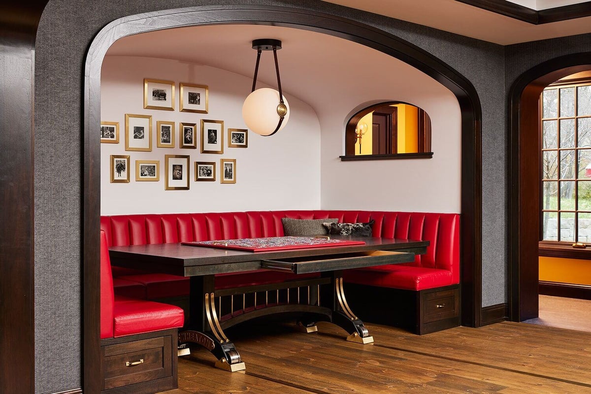 Intimate dining area featuring red leather banquette seating and black table by MA Peterson in Twin Cities