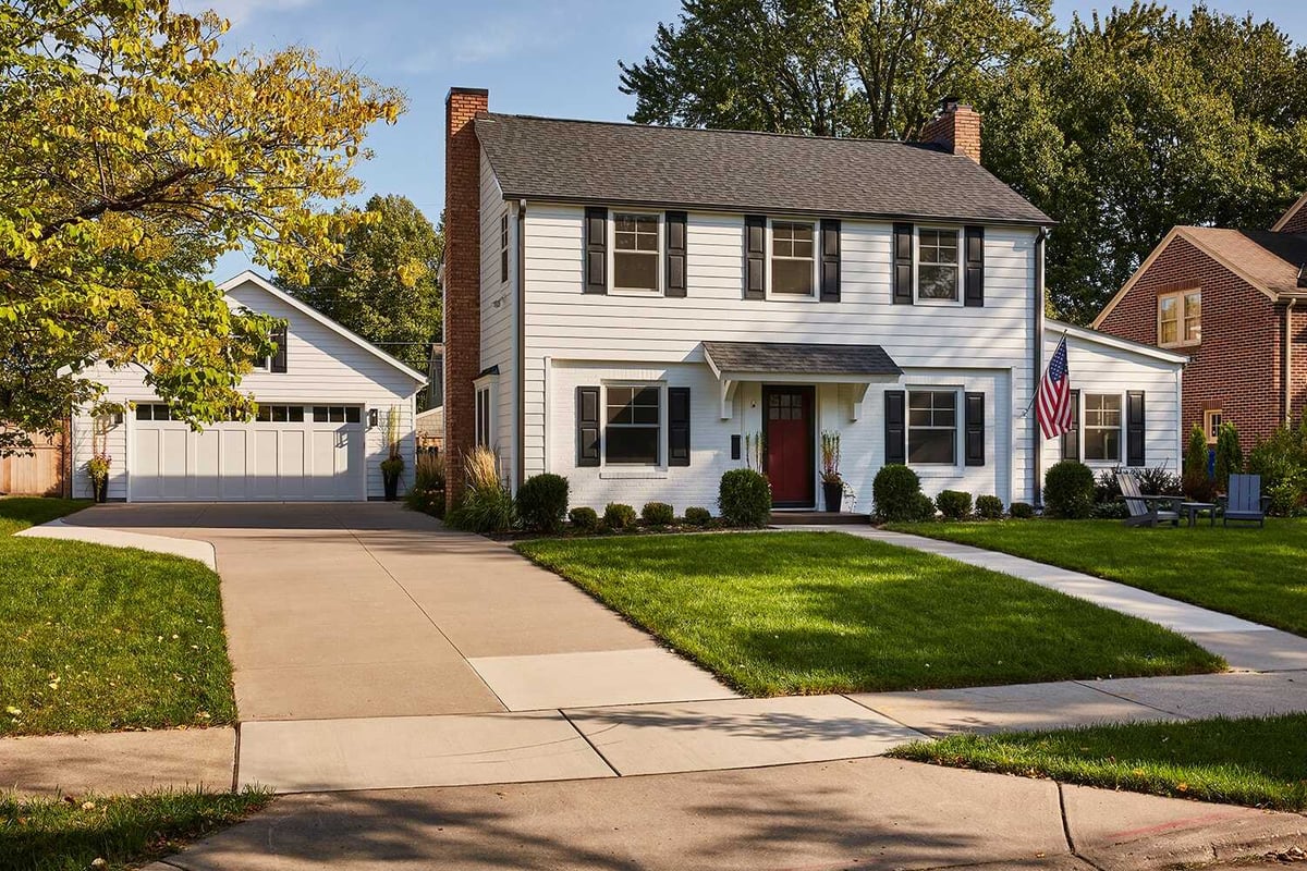 Driveway leading to a remodeled white house in Twin Cities by MA Peterson