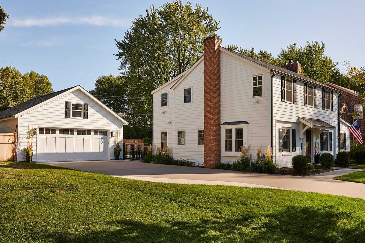 Side view of remodeled white house with detached garage in Twin Cities by MA Peterson