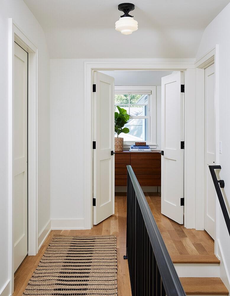 Upstairs hallway with view into a sunlit room in a Twin Cities home remodeled by MA Peterson