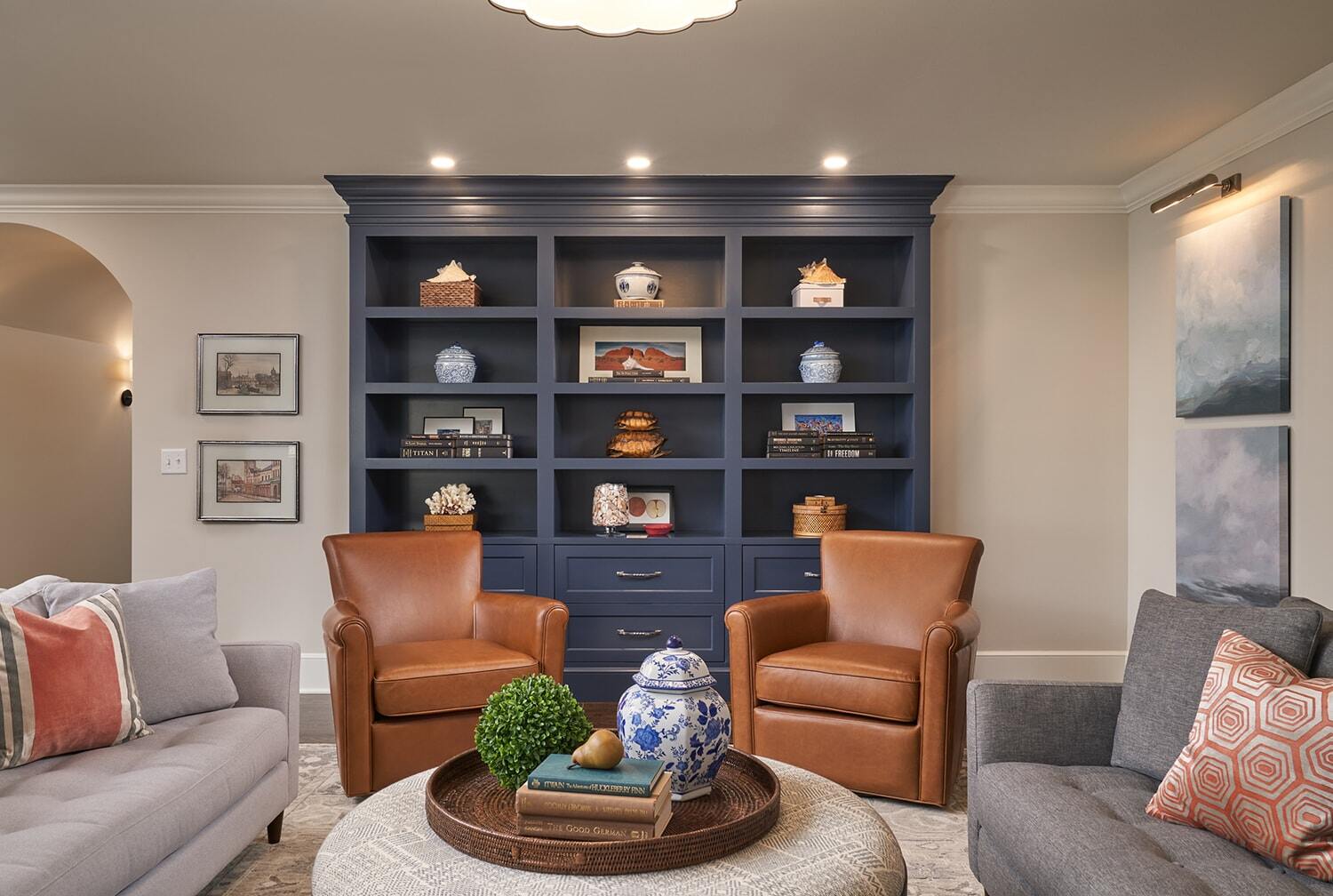 Living room with a navy blue built-in bookshelf with emphasis on style and decor by MA Peterson in Twin Cities